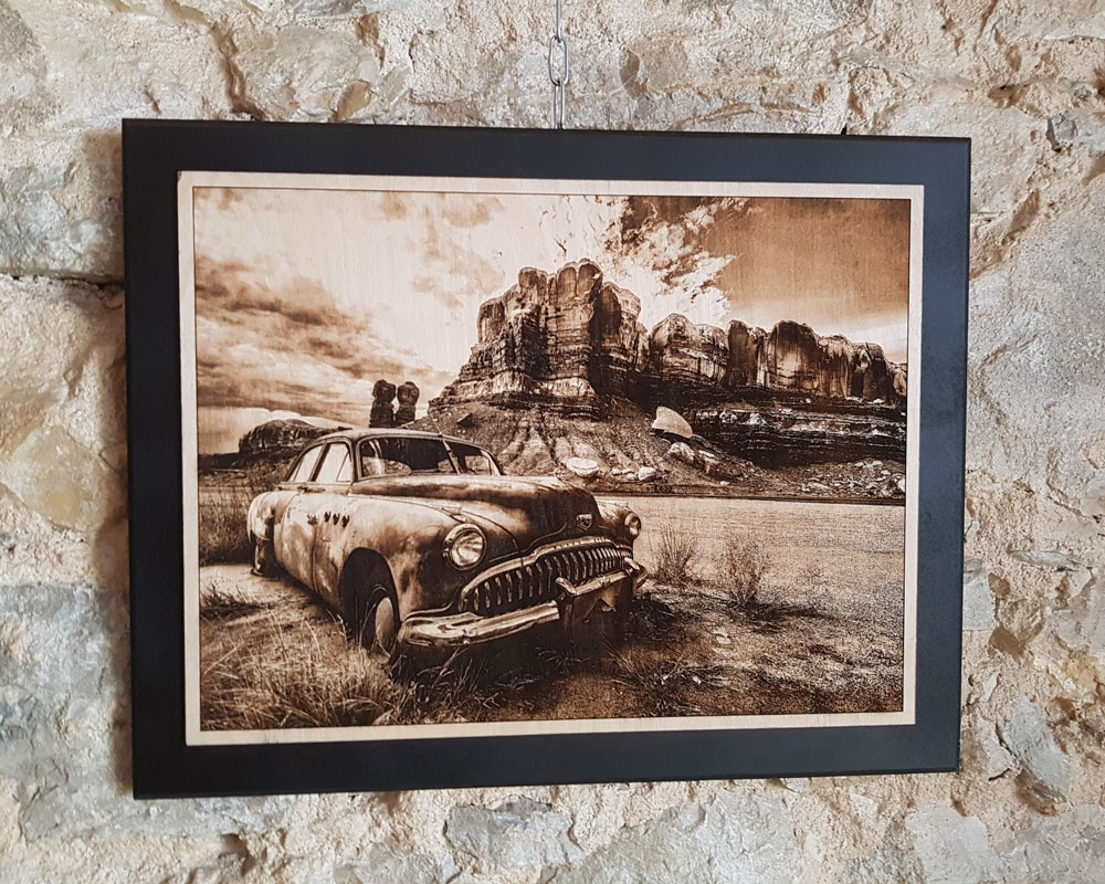 Cadre gravure photo sur bois DHLaser Design avec paysage désertique voiture ancienne accroché sur mur en pierre