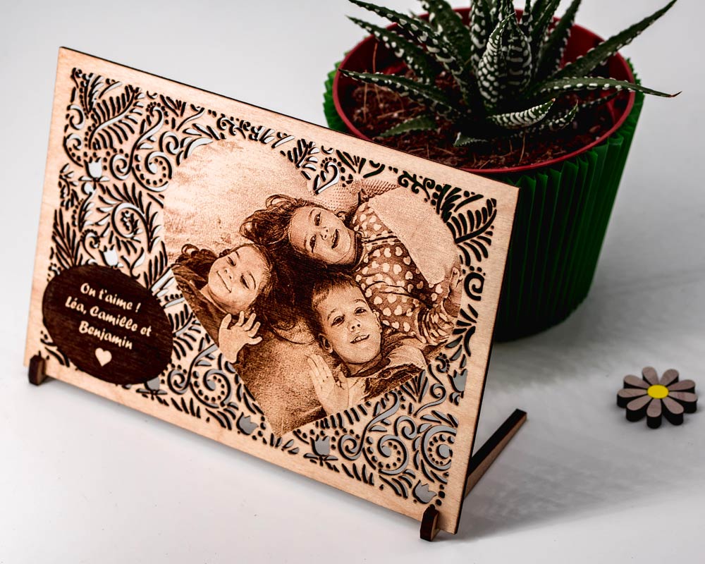 Carte bois personnalisee photo famille DHLaser Design gravure On t aime sur support incline en bois posee pres d une plante verte