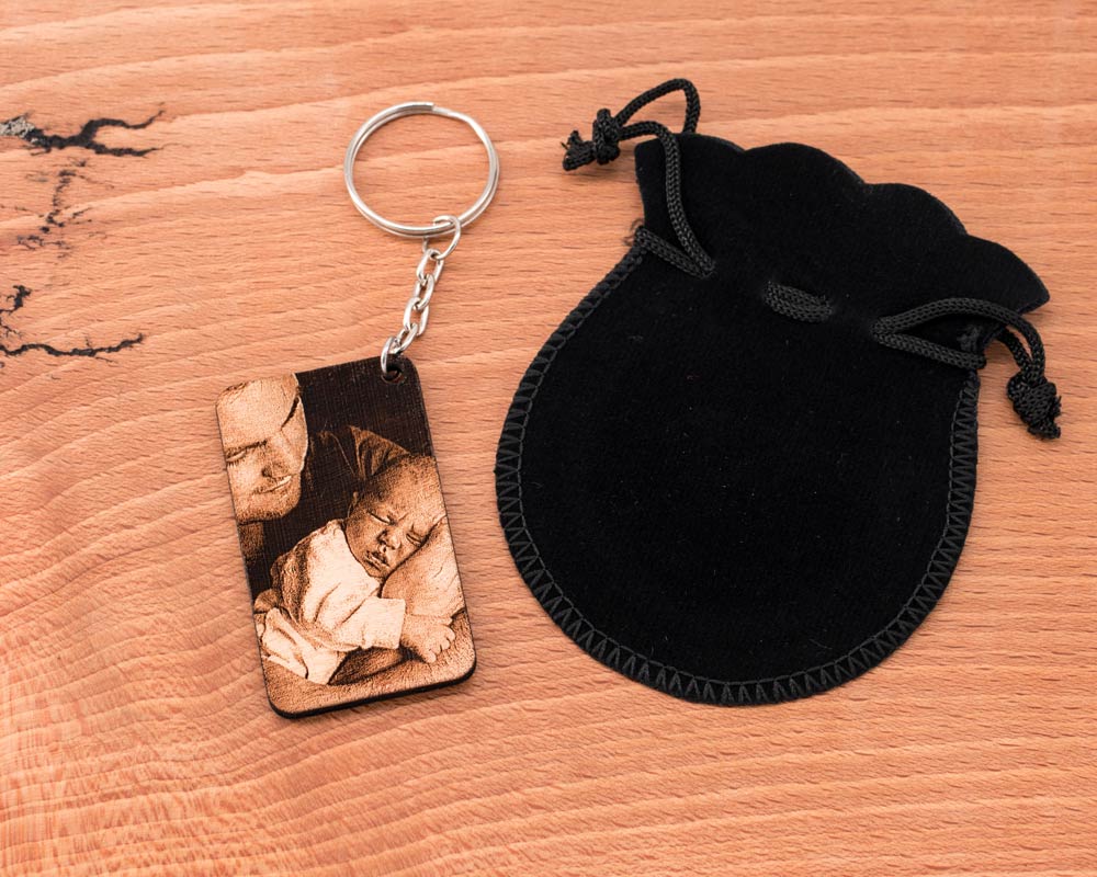 Porte clé photo personnalisé en bois DHLaser Design gravure papi et enfant avec pochette noire sur surface bois clair